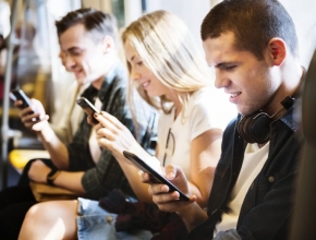 Junge Erwachsene nutzen Smartphone in U-Bahn